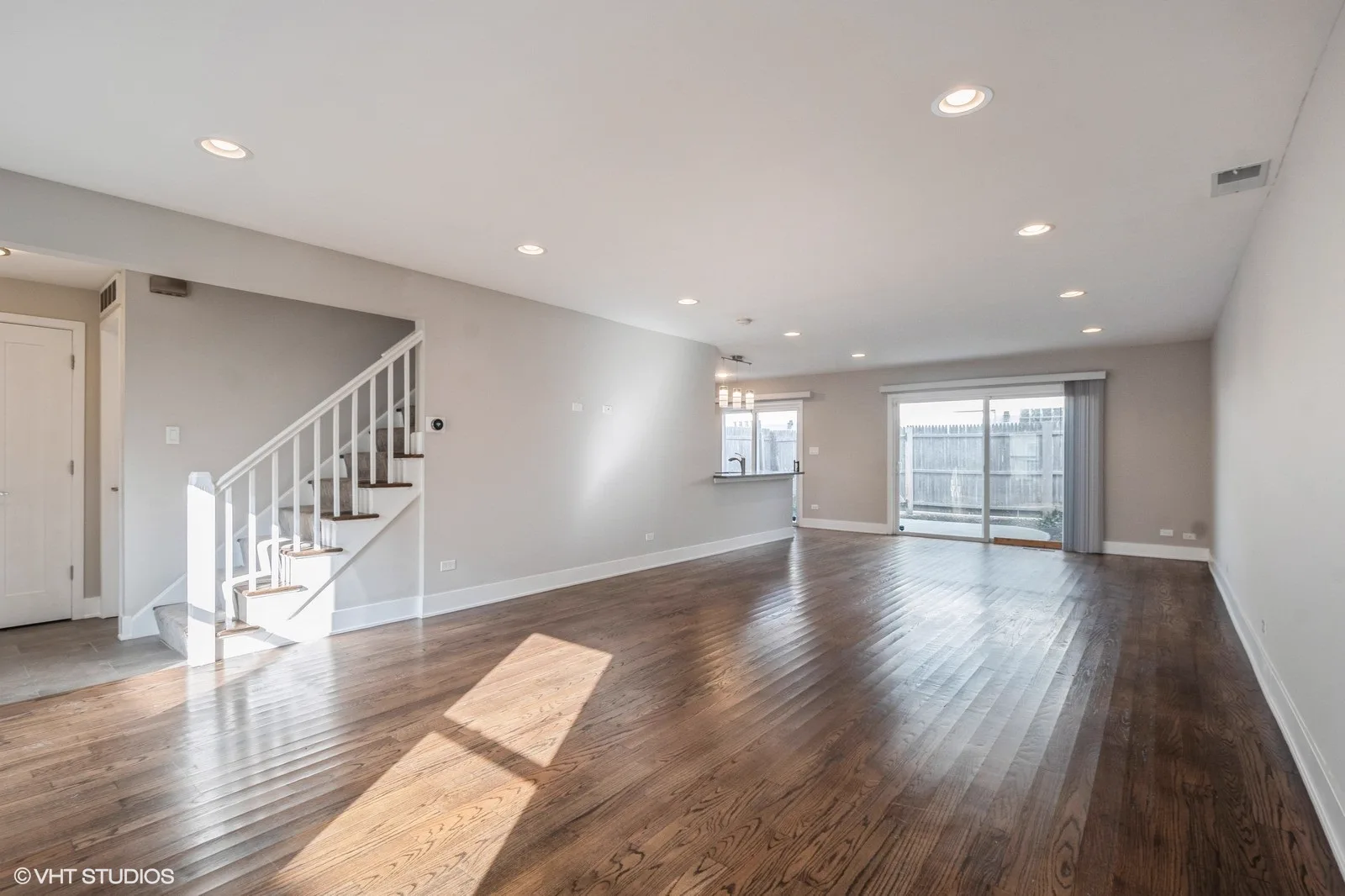 Open living room with hardwood floors and staircase